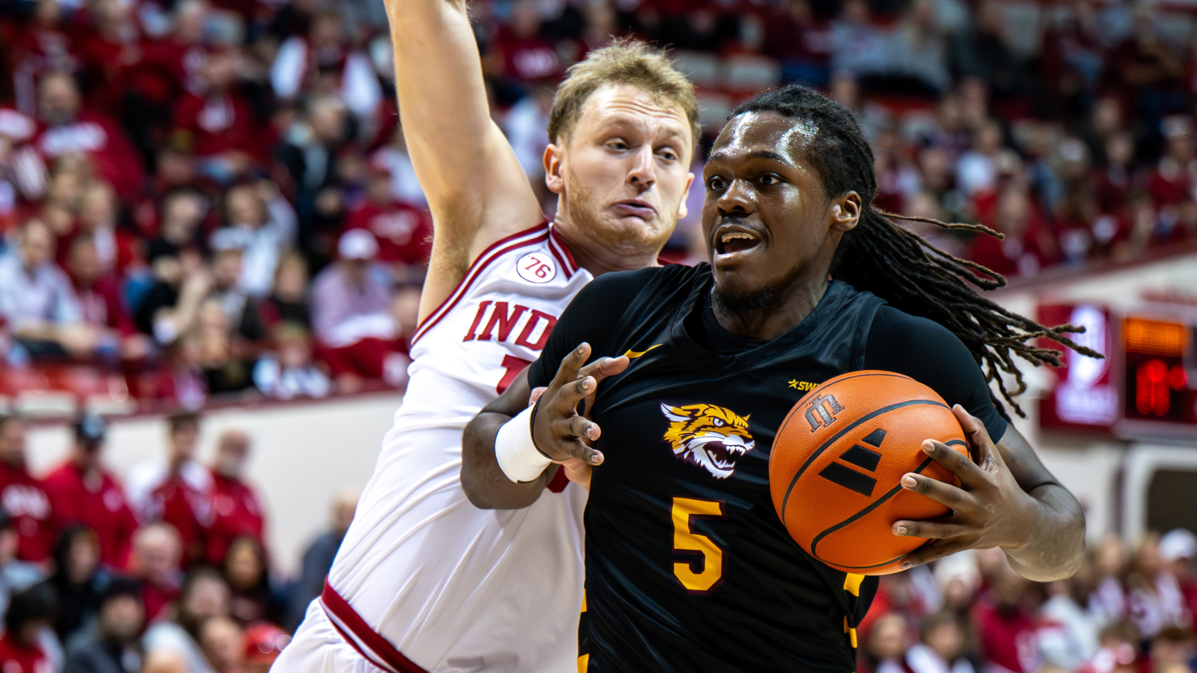 Bethune-Cookman forward Quentin Heady (5) is defended by Indiana forward Tucker Devries (12) during the first half of an NCAA college basketball game, Saturday, Nov. 29, 2025, in Bloomington, Ind. (AP Photo/Doug McSchooler)
