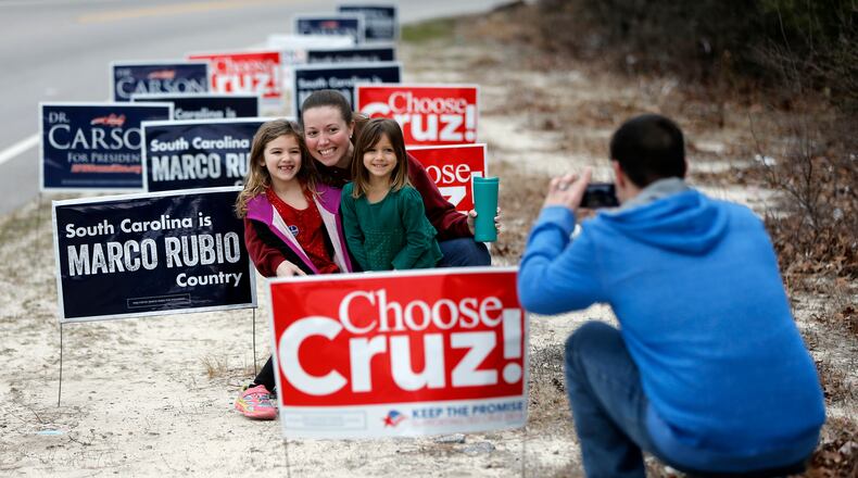 John Mew, right, photographs his wife Amy, and daughters Ireland, 6, left, and Sailor, 4, after voting in the South Carolina Republican presidential primary Saturday, Feb. 20, 2016, at Emmanuel Lutheran Church in West Columbia, S.C. (AP Photo/Matt Rourke)
