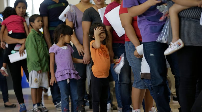In this June 20, 2014 photo, immigrants who entered the U.S. illegally stand in line for tickets at the bus station after they were released from a U.S. Customs and Border Protection processing facility in McAllen, Texas. The immigrants entered the country through an area referred to as zone nine. (AP Photo/Eric Gay)