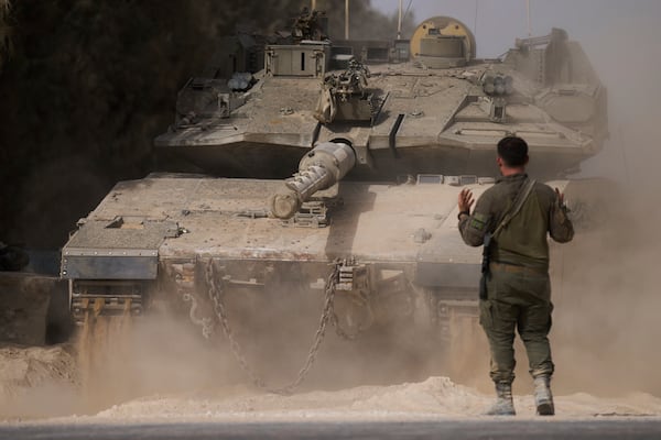 An Israeli soldier directs a tank at a staging area near the border with the Gaza Strip, in southern Israel, Tuesday, July 1, 2025. (AP Photo/Ariel Schalit)