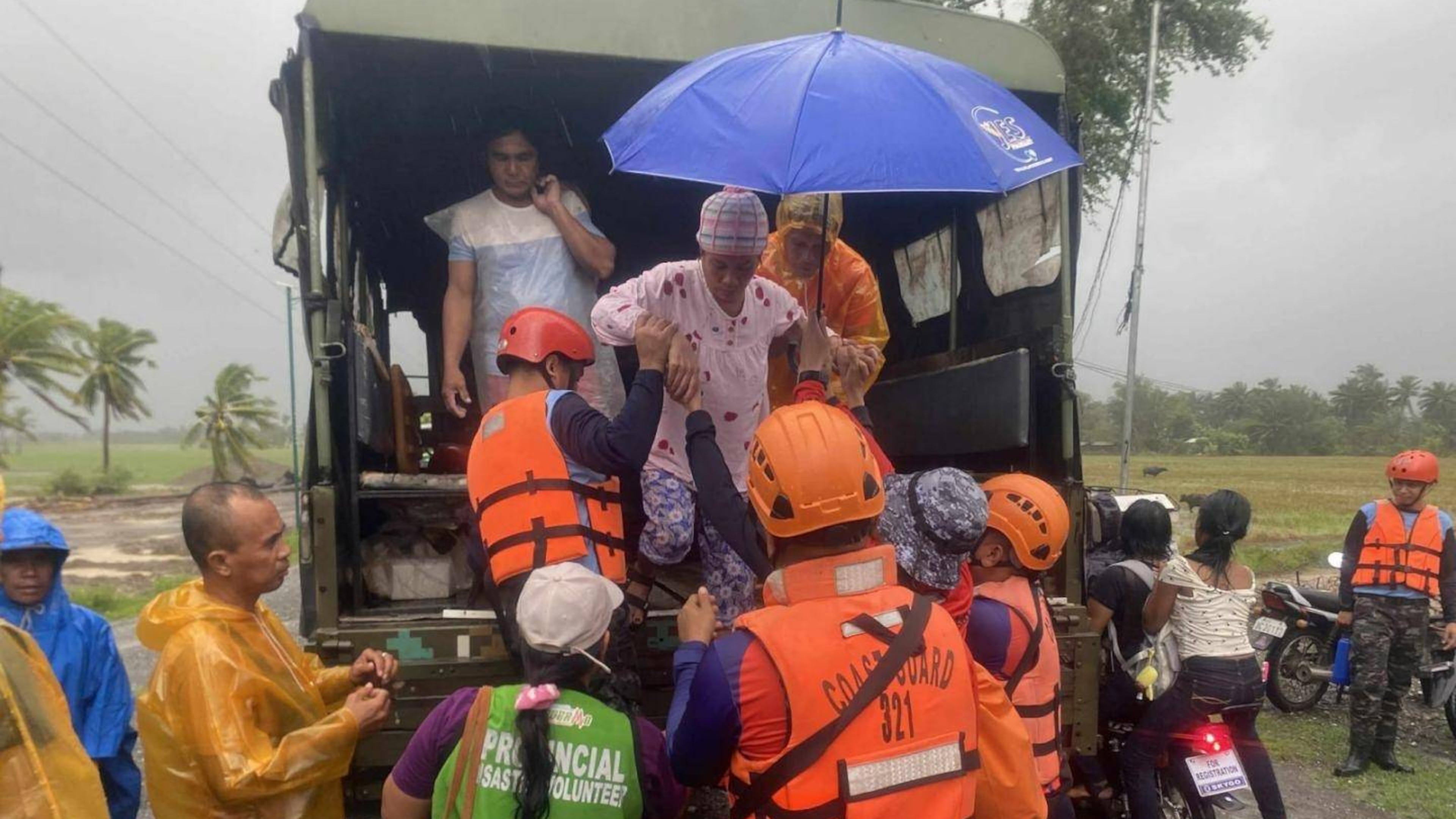 In this photo provided by the Philippine Coast Guard, rescuers evacuate residents in Sablayan, Occidental Mindoro province of the Philippines as Typhoon Fung-wong batters the country on Sunday, Nov. 9 2025. (Philippine Coast Guard via AP)