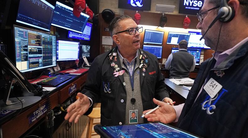 Traders Jonathan Mueller, left, and Michael Capolino confer on the floor of the New York Stock Exchange, Thursday, April 23, 2026. (AP Photo/Richard Drew)