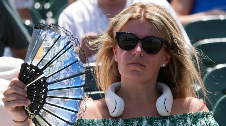 FILE - A baseball fan cools off before a game between the San Diego Padres and the Chicago Cubs in Chicago, July 1, 2026. (AP Photo/Nam Y. Huh, File)