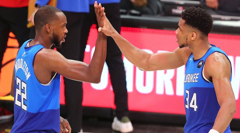 Milwaukee Bucks forwards Giannis Antetokounmpo (right) and Khris Middleton celebrate the 113-102 win over the Hawks in Game 3 of the Eastern Conference finals Sunday, June 27, 2021, at State Farm Arena in Atlanta. (Curtis Compton / Curtis.Compton@ajc.com)