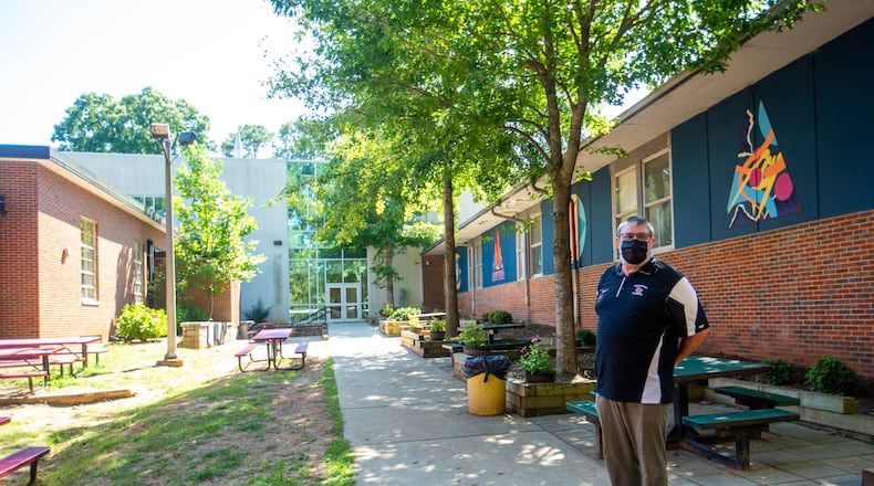 The DeKalb County School System has assessed and fix school structures across the district through the summer. Druid Hills High School Principal Mark Joyner, points out the outdoor lunch area during a tour of the school’s updates Wednesday, Aug 31, 2022 where tree roots backed up sewage pipes last year. The tree was removed and cast iron pipes replaced with modern plumbing before school opened this year. (Jenni Girtman for The Atlanta Journal-Constitution)