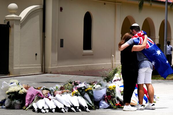 A couple mourned today at a memorial for the shooting victims at Bondi Beach in Sydney, Australia. (Mark Baker/AP)