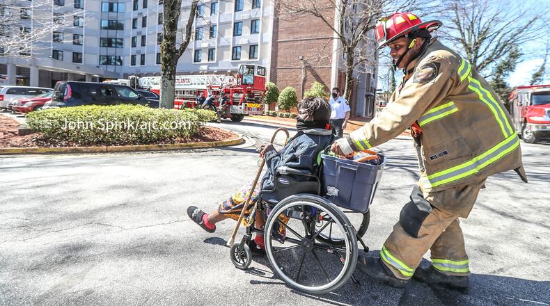 Atlanta fire Capt. Michael Williams moves 77-year-old Carrie Louise Sims following a fire at a senior living community.