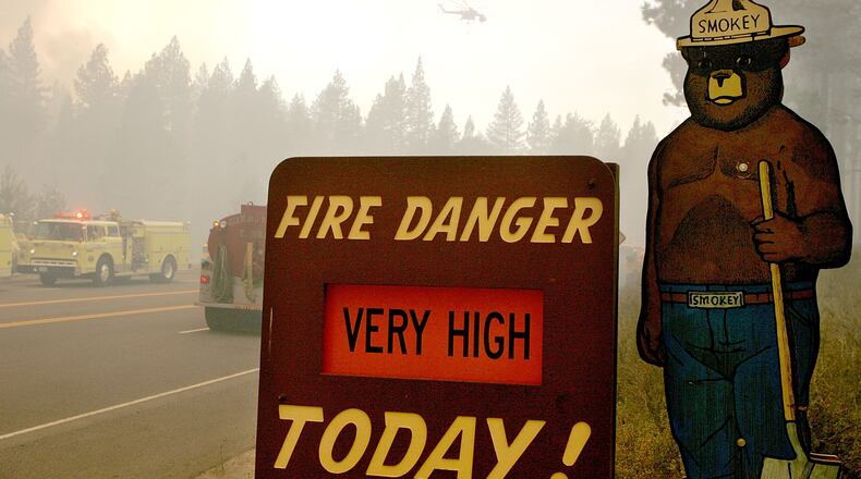 A Smokey the Bear sign is seen as firefighters battle the Angora fire as it approaches homes June 26, 2007 in South Lake Tahoe, California. =