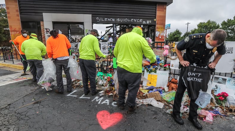 . Atlanta police and sanitation crews finished removing protesters and their belongings from outside the Wendy’s on Monday July 6, 2020 where Rayshard Brooks was shot and killed by an officer last month. The last concrete barricade was put in place around noon. Some of the protesters milled nearby while a worker from the BP gas station next door pulled boards off the windows. Monday’s cleanup followed a violent holiday weekend that started Saturday night when 8-year-old Secoriea Turner was fatally shot while sitting in a car near the restaurant. Atlanta Mayor Keisha Lance Bottoms denounced the violence in an emotional press conference at police headquarters in which she and Turner’s family urged people to come forward with information about the girl’s killers. About 9:30 a.m. Monday, uniformed officers and multiple workers in neon attire tossed flowers and other items from a makeshift memorial outside the Wendy’s into garbage bags. The site has served as ground zero for protests since Brooks was shot in the parking lot following an attempted DUI arrest in the drive-thru line June 12. The restaurant was destroyed during a large protest the next day. Three people have been arrested on arson charges in connection with the incident. JOHN SPINK/JSPINK@AJC.COM