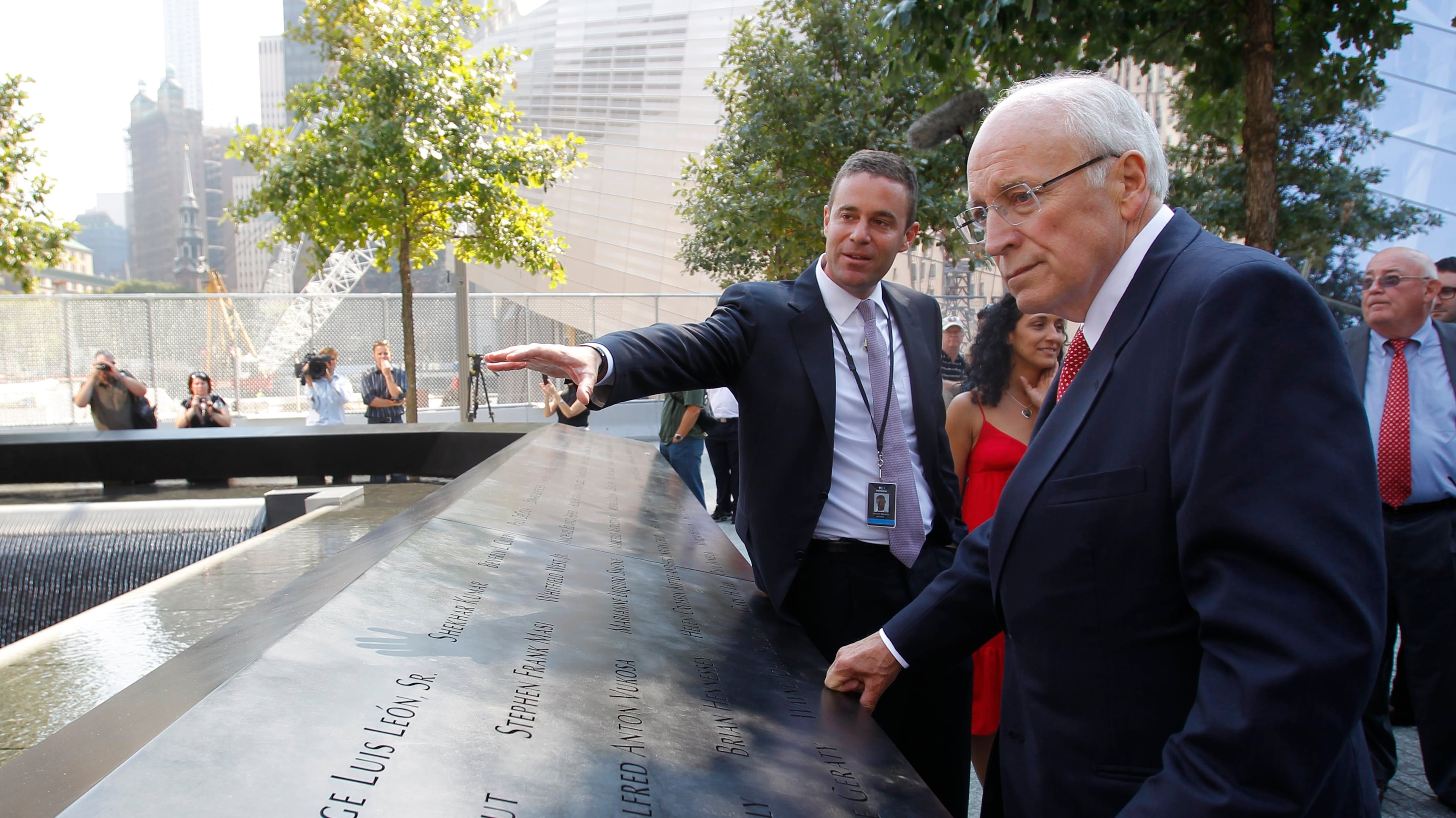 FILE - Former U.S. Vice President Dick Cheney, right, listens to 9/11 Memorial President Joe Daniels, center, as he looks at one of the panels inscribed with the names of the attack victims during a visit to the 9/11 memorial plaza in the World Trade Center site in New York Monday, Sept. 12, 2011, on the first day that the memorial was opened to the public. (AP Photo/Mike Segar, file)