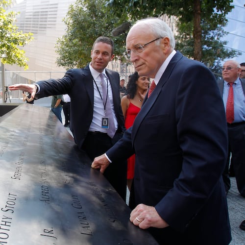 FILE - Former U.S. Vice President Dick Cheney, right, listens to 9/11 Memorial President Joe Daniels, center, as he looks at one of the panels inscribed with the names of the attack victims during a visit to the 9/11 memorial plaza in the World Trade Center site in New York Monday, Sept. 12, 2011, on the first day that the memorial was opened to the public. (AP Photo/Mike Segar, file)