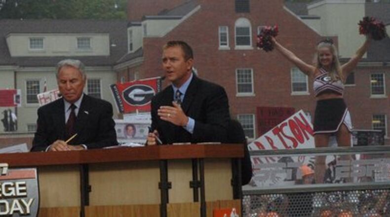 A cheerleader pops up over the left shoulder of Kirk Herbstreit during the ESPN College GameDay broadcast Sept. 27, 2008. To Herbstreit's right is Lee Corso, who picked Alabama to win the top-10 showdown later that night.