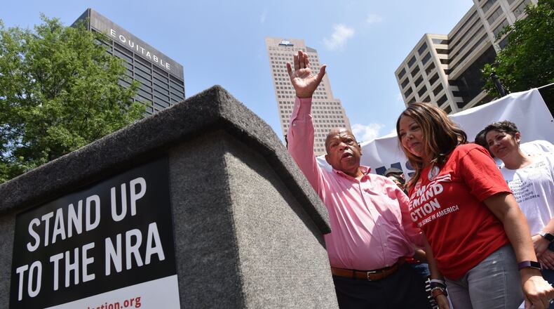 U.S. Rep. John Lewis waves after he spoke to the crowd at a protest Saturday in Woodruff Park. The protest was organized by gun control advocates, who held it blocks away from the National Rifle Association’s annual convention in downtown Atlanta. HYOSUB SHIN / HSHIN@AJC.COM