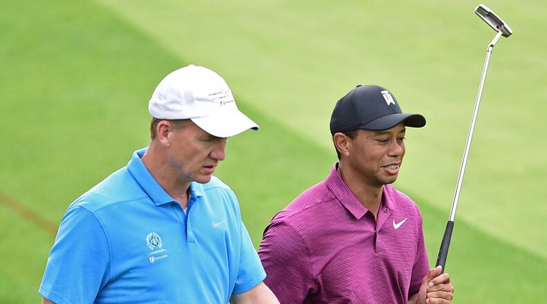 Peyton Manning, left, and Tiger Woods walk to the green on the eleventh hole during the pro-am for the the Memorial golf tournament Wednesday, May 30.