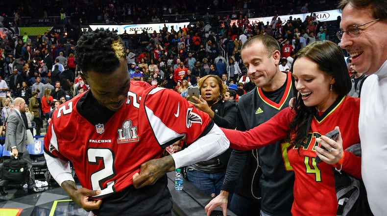 Atlanta Hawks guard Dennis Schroder puts on a Super Bowl-bound Atlanta Falcons’ Matt Ryan jersey that fans gave him after an NBA basketball game against the Orlando Magic, Saturday, Feb. 4, 2017, in Atlanta. (AP Photo/John Amis)