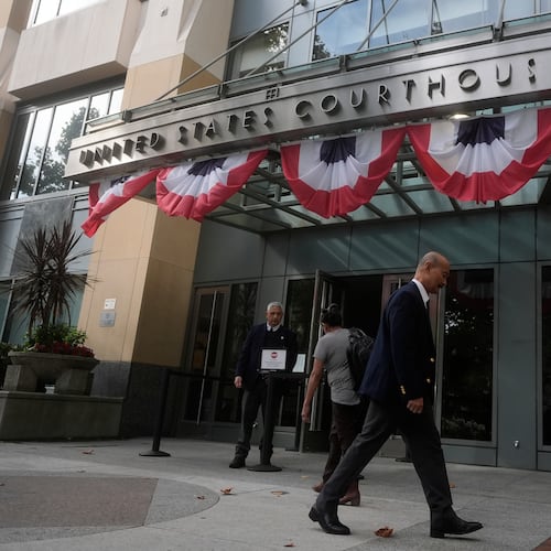 People walk outside of a Federal Courthouse Wednesday, Aug. 12, 2026, in Oakland, Calif. (AP Photo/Jeff Chiu)