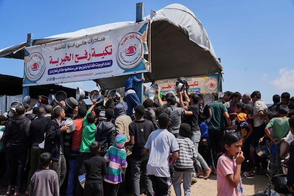 Palestinians struggle to get donated food at a community kitchen in Khan Younis, Gaza Strip, Monday, May 5, 2025. (AP Photo/Abdel Kareem Hana)