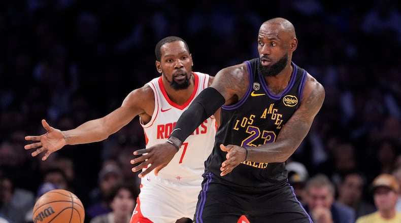 Los Angeles Lakers forward LeBron James, right, passes the ball while under pressure from Houston Rockets forward Kevin Durant during the first half in Game 2 of a first-round NBA playoffs basketball series Tuesday, April 21, 2026, in Los Angeles. (AP Photo/Mark J. Terrill)