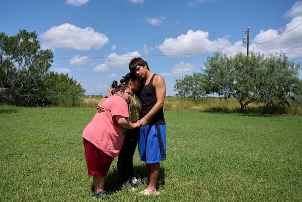 Juanita is hugged by her children, Jose, 15, and daughter Marely, 17, who has Down syndrome, Tuesday, June 17, 2025, during a portrait in Hidalgo County, Texas. (AP Photo/Jacquelyn Martin)