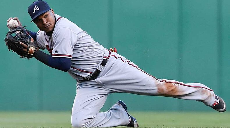 Erick Aybar attempts a throw from his knees during game against Pittsburgh in May.