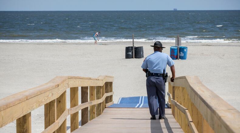 A Georgia State Patrol officer keeps watch at Tybee Island beach last year during social distancing efforts during the coronavirus pandemic. A 15-year-old Alabama girl died Saturday after being struck by lightning while swimming in the area, according to reports.