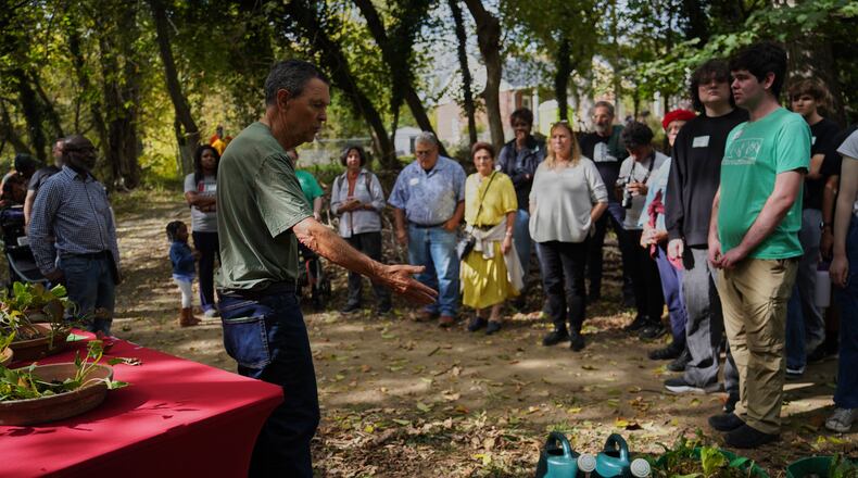 Visitors learn about fall crops like lettuce and kale while on a walking tour of Collins Avenue during the Baltimore Gift Economy's third annual "Finding Home" gathering, Sunday, Oct. 19, 2025, in Baltimore. (AP Photo/Jessie Wardarski)