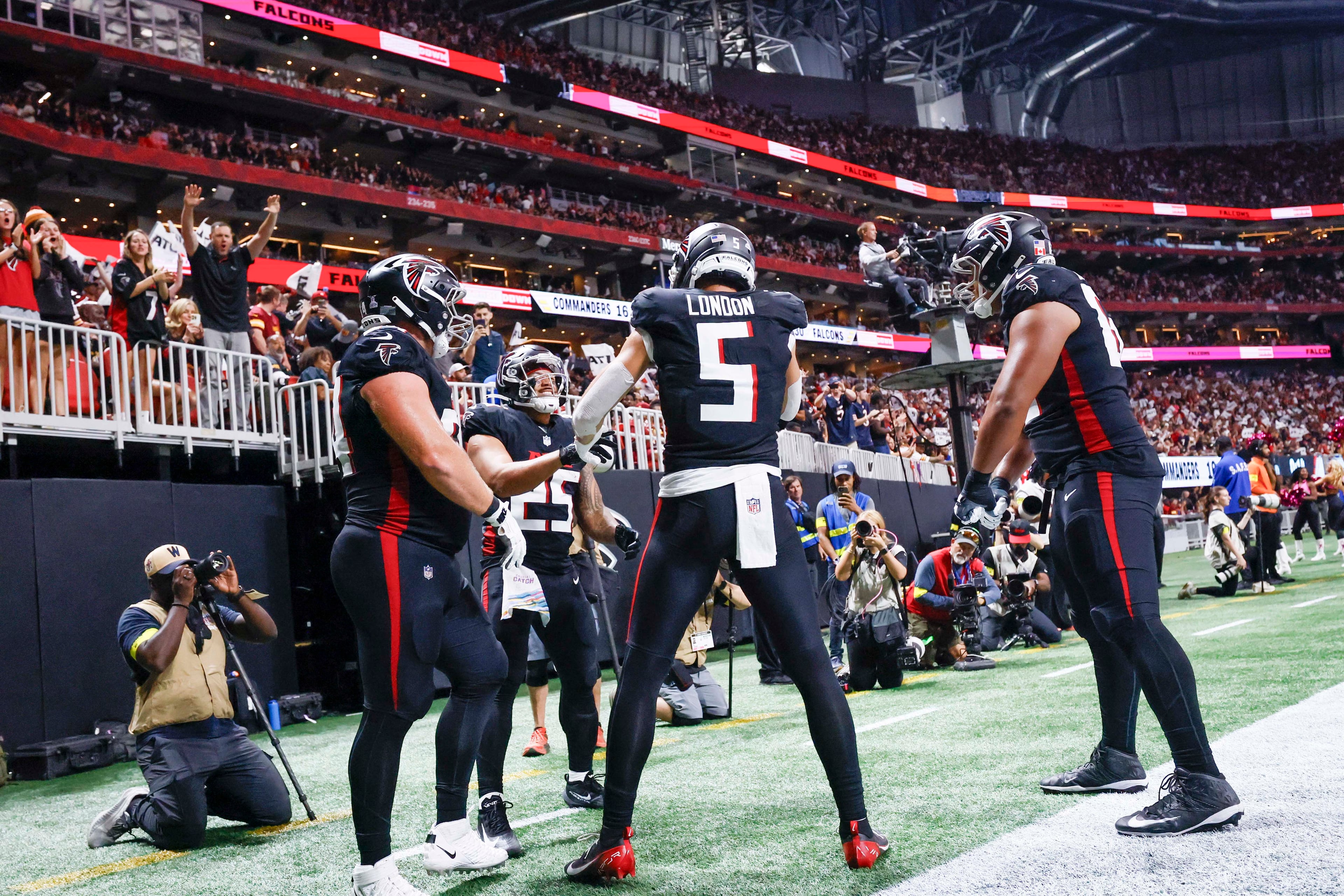 Atlanta Falcons running back Tyler Allgeier (second from left) is congratulated by teammates after his touchdown during the second half of an NFL game against the Washington Commanders at Mercedes-Benz Stadium in Atlanta on Sunday, September 28, 2025. (Miguel Martinez/AJC)