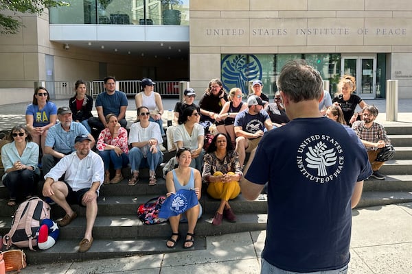 U.S. Institute of Peace employees hold an impromptu celebration on the steps of the U.S. Institute of Peace, Monday, May 19, 2025, in Washington, after federal district Judge Beryl A. Howell blocked the Trump administration from moving forward with the dismantling the organization. (AP Photo/Gary Fields)