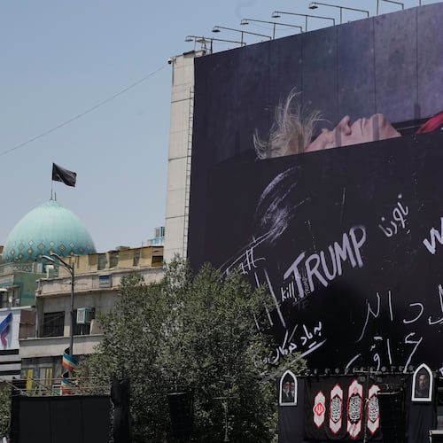 A billboard depicting U.S. President Donald Trump lying on what appears to be a coffin and bearing anti-Trump messages, including the phrase "We Kill Trump," is seen at Islamic Revolution Square in downtown Tehran, Iran, Wednesday, July 15, 2026. (AP Photo/Vahid Salemi)