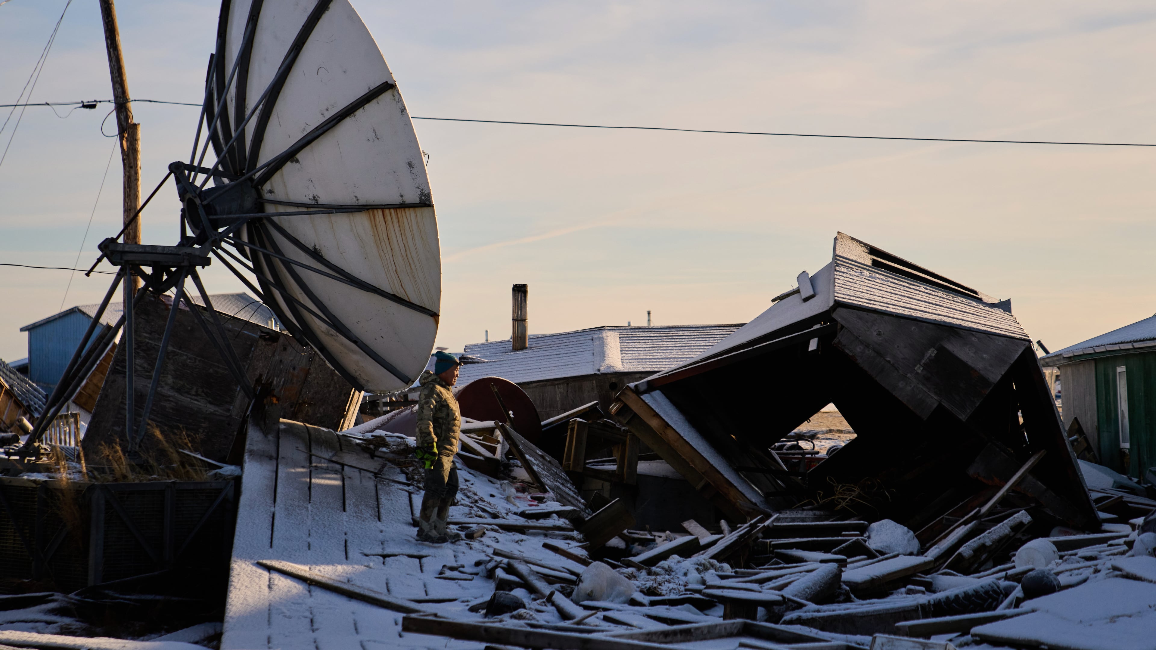Harry Friend walks among debris caused by the remnants of Typhoon Halong hitting the village and region earlier in the month, Monday, Oct. 27, 2025, in Kwigillingok, Alaska. (AP Photo/Lindsey Wasson)
