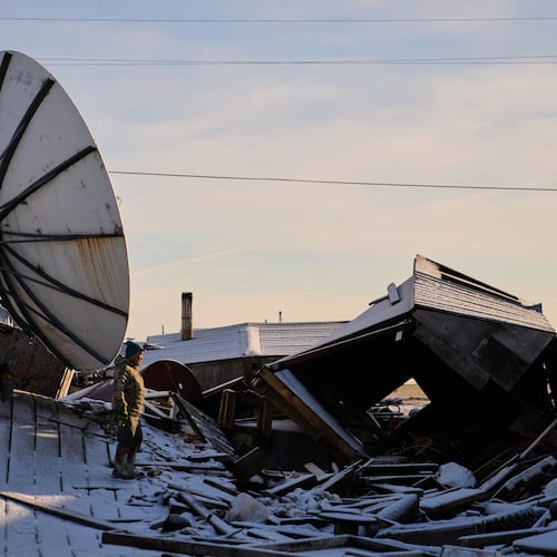 Harry Friend walks among debris caused by the remnants of Typhoon Halong hitting the village and region earlier in the month, Monday, Oct. 27, 2025, in Kwigillingok, Alaska. (AP Photo/Lindsey Wasson)