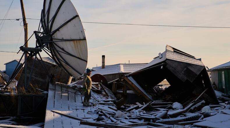 Harry Friend walks among debris caused by the remnants of Typhoon Halong hitting the village and region earlier in the month, Monday, Oct. 27, 2025, in Kwigillingok, Alaska. (AP Photo/Lindsey Wasson)