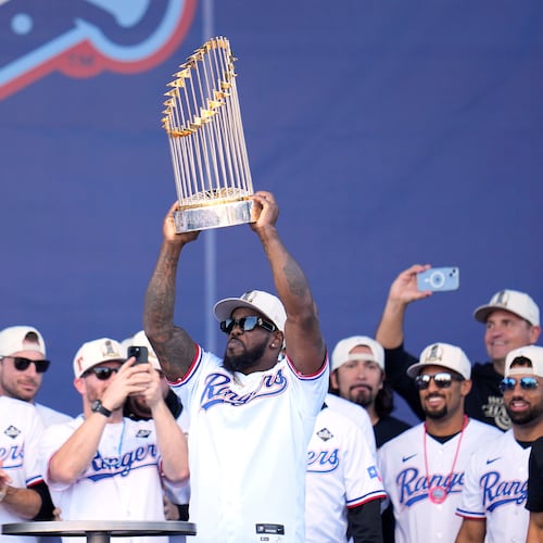 FILE - Texas Rangers' Adolis Garcia, surrounded by teammates and staff, holds up the Commissioner's Trophy during a World Series baseball championship celebration, Friday, Nov. 3, 2023, in Arlington, Texas. (AP Photo/Julio Cortez, File)