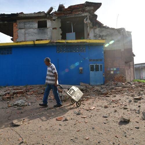 A man walks past a damaged home in Moron, near the epicenter of two earthquakes that struck Venezuela the day before, Thursday, June 25, 2026. (AP Photo/Jacinto Oliveros)