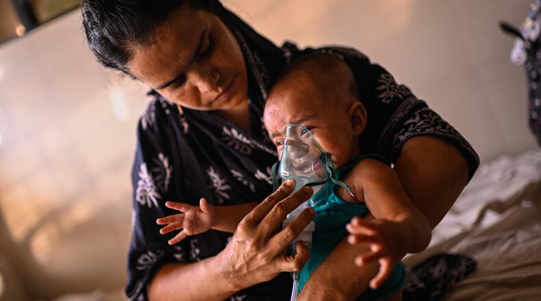 A mother administers a nebulizer treatment for her child suffering from measles at the Infectious Diseases Hospital in Dhaka, Bangladesh, Monday, April 6, 2026, amid a countrywide outbreak. (AP Photo/Mahmud Hossain Opu)