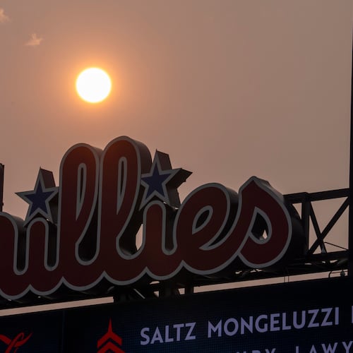 The Sun has an orange cast from smoke coming down from the Canadian wildfires as it sets near the Philadelphia Phillies scoreboard during the fourth inning of a baseball game against the New York Mets, Thursday, July 16, 2026, in Philadelphia. (AP Photo/Chris Szagola)