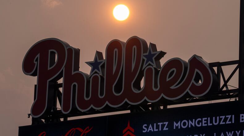 The Sun has an orange cast from smoke coming down from the Canadian wildfires as it sets near the Philadelphia Phillies scoreboard during the fourth inning of a baseball game against the New York Mets, Thursday, July 16, 2026, in Philadelphia. (AP Photo/Chris Szagola)