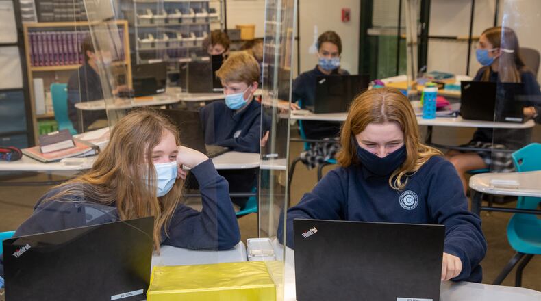 Kaitlyn Moss (left) & Kelsey Brown share a computer screen between plexiglass in Mr Brad LantisÕ technology class at Cornerstone Christian Academy in Peachtree Corners on Monday January 25th, 2021 For a story on the Top Workplace small category. PHIL SKINNER FOR THE ATLANTA JOURNAL-CONSTITUTION.