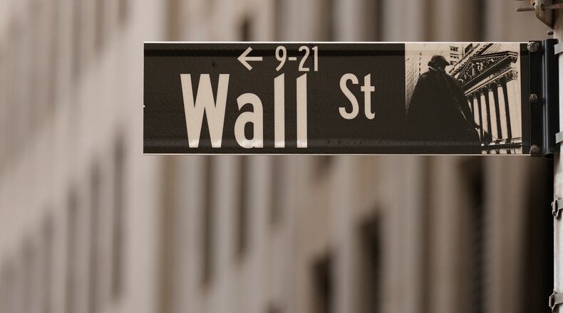 FILE - A Wall Street sign is seen outside of the New York Stock Exchange in New York, Monday, March 30, 2026. (AP Photo/Seth Wenig, File)