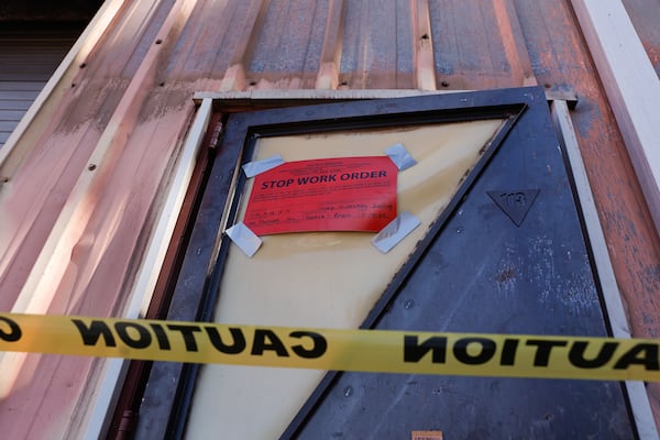 A stop work order sign is taped to a door on the main building at South River Arts Studio on Friday, Nov. 14, 2025, in DeKalb County. A Wednesday blaze ravaged one of three warehouses on the property. (Natrice Miller/AJC)