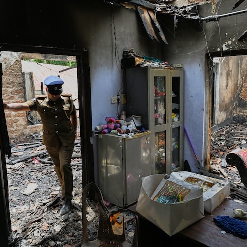 A Sri Lankan police officer inspects a charred elderly care home following an overnight fire in Anguruwatota, Sri Lanka, Thursday, June 4, 2026. (AP Photo)