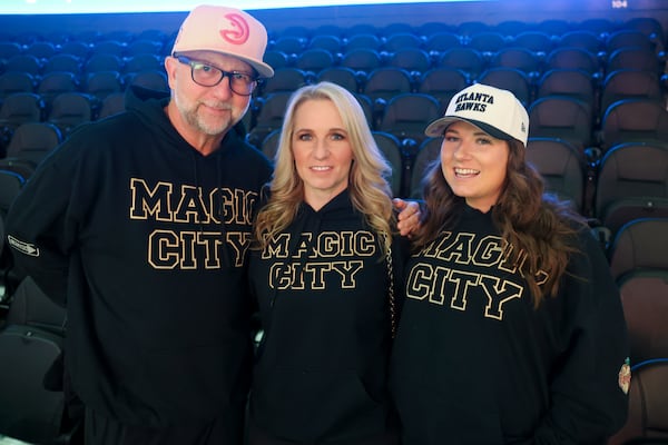 Atlanta Hawks fans wear Magic City sweatshirts that they made themselves before the NBA game against the Orlando Magic at State Farm Arena, Monday, March 16, 2026, in Atlanta. Pictured from left to right; Randy Hall, Jennifer Hall and Jennifer’s daughter Brooke Jordan, of Atlanta. (Jason Getz/AJC)