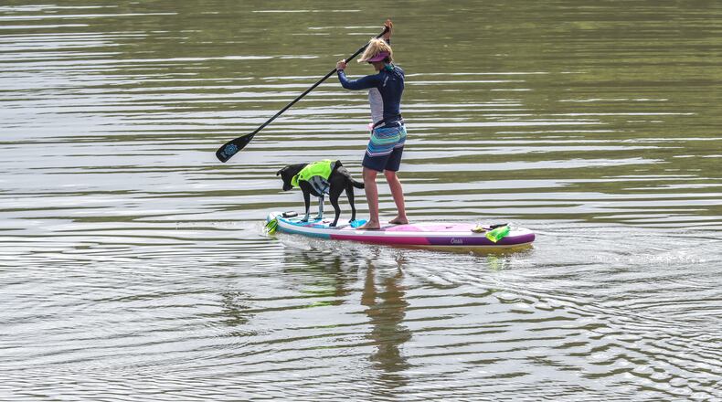On a hot sunny day in June, Nisey Woods along with her dog Cali headed out from the river access at Morgan Falls Overlook Park in Sandy Springs on their paddle boards. John Spink / John.Spink@ajc.com)