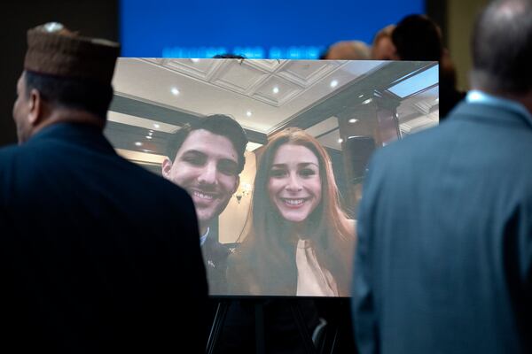 Visitors walk past a photo of slain Israeli Embassy staff members Yaron Lischinsky, left, and Sarah Milgrim, right, before a service to mark the reopening of the Capital Jewish Museum after the two were killed following an event at the museum, Thursday, May 29, 2025, in Washington. (AP Photo/Mark Schiefelbein)