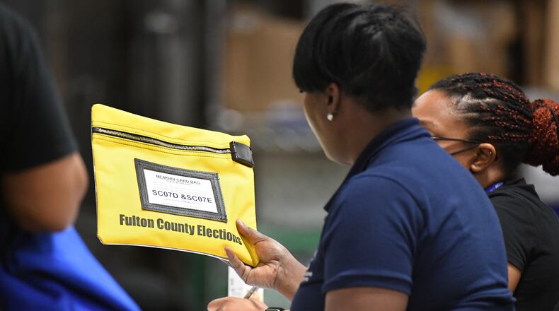 An election worker checks memory card bag contained votes at Fulton County Election Preparation Center on Tuesday, May 24, 2022. (Hyosub Shin / Hyosub.Shin@ajc.com)