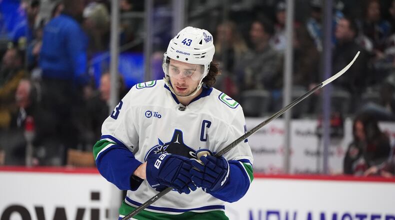 Vancouver Canucks defenseman Quinn Hughes waits for play to begin in the third period of an NHL hockey game against the Colorado Avalanche Tuesday, Dec. 2, 2025, in Denver. (AP Photo/David Zalubowski)
