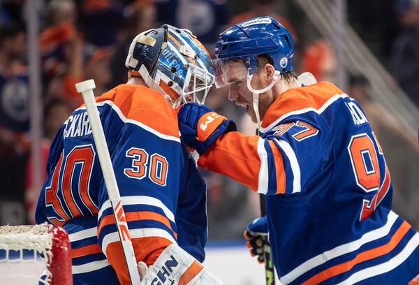 Edmonton Oilers goalie Calvin Pickard (30) and Connor McDavid (97) celebrate the win over the Los Angeles Kings in NHL playoff action in Edmonton, Alberta, Friday, April 25, 2025. (Jason Franson/The Canadian Press via AP)