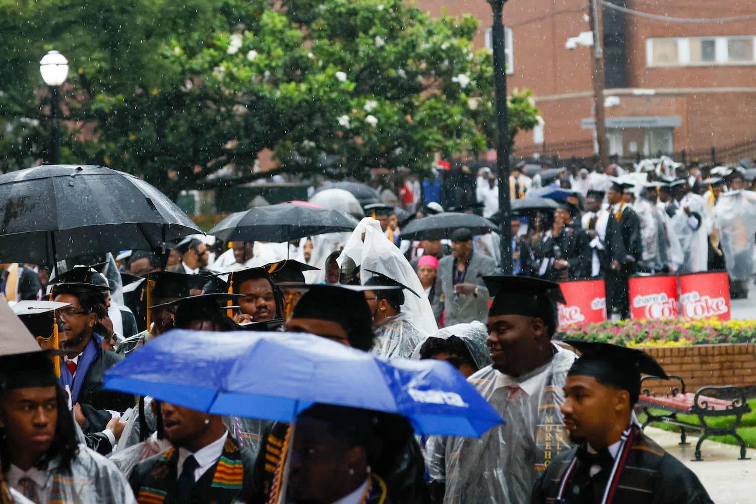 Graduates cover from the rain as they walk to the Martin Luther King International Chapel to continue the ceremony indoors at Morehouse College’s 141st Commencement Ceremony on Sunday, May 18, 2025.
(Miguel Martinez/ AJC)