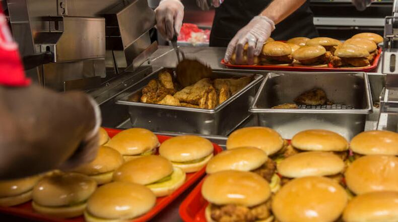 Workers prepare sandwiches to be given away at Chick-fil-A’s first location in New York, Sept. 23, 2015. At a time when many fast-food restaurants are struggling, privately-held Chick-fil-A expects to post double-digit growth this year, but the chain remains unfamiliar to most New Yorkers — even some of those hired for this Manhattan location. (Hiroko Masuike/The New York Times)