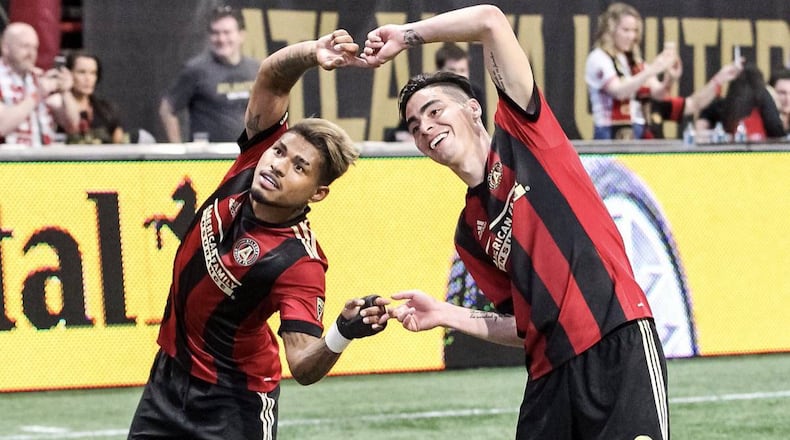 Atlanta United's Miguel Almiron (right) and Josef Martinez celebrate Almiron's goal in Saturday's 4-0 win against Orlando City at Mercedes-Benz Stadium.